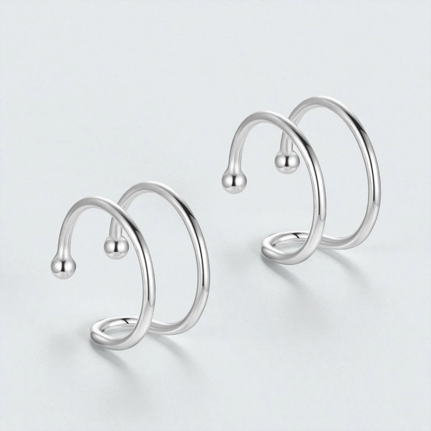 Pair of 925 sterling silver double loop ear cuffs displayed on light background showing minimalist non pierced hypoallergenic hoop design