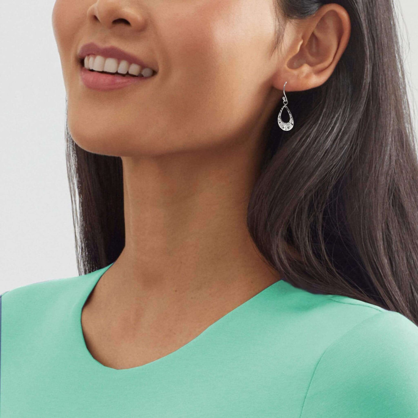 Dainty sterling silver teardrop earrings elevate a night-out outfit.