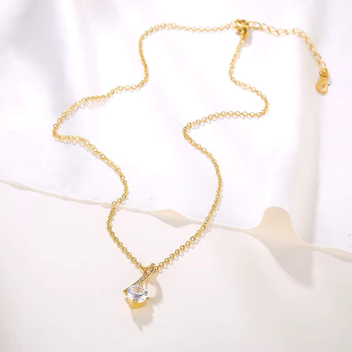 Trendy layered jewelry look featuring 18K gold plated CZ pendant chain necklace.