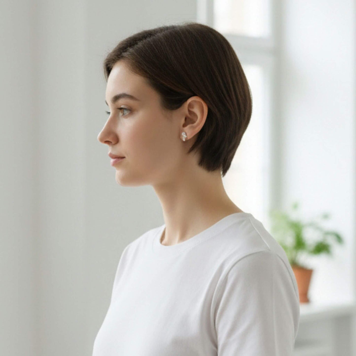 Woman wearing minimalist sterling silver droplet stud earrings