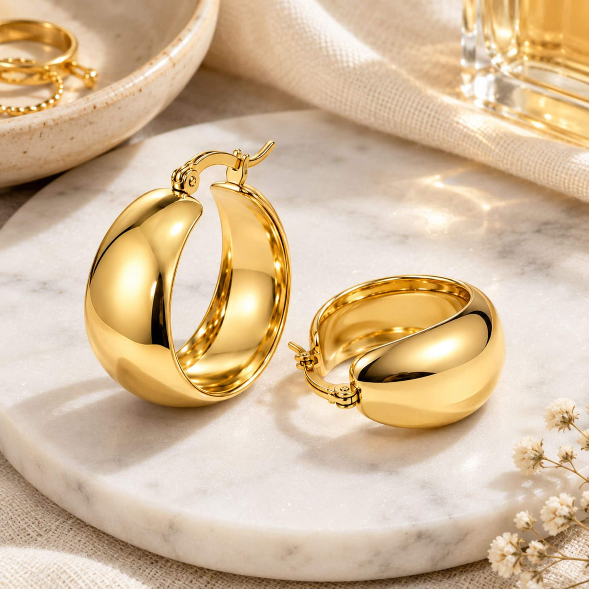 18K gold plated chunky hoop earrings styled on a marble surface