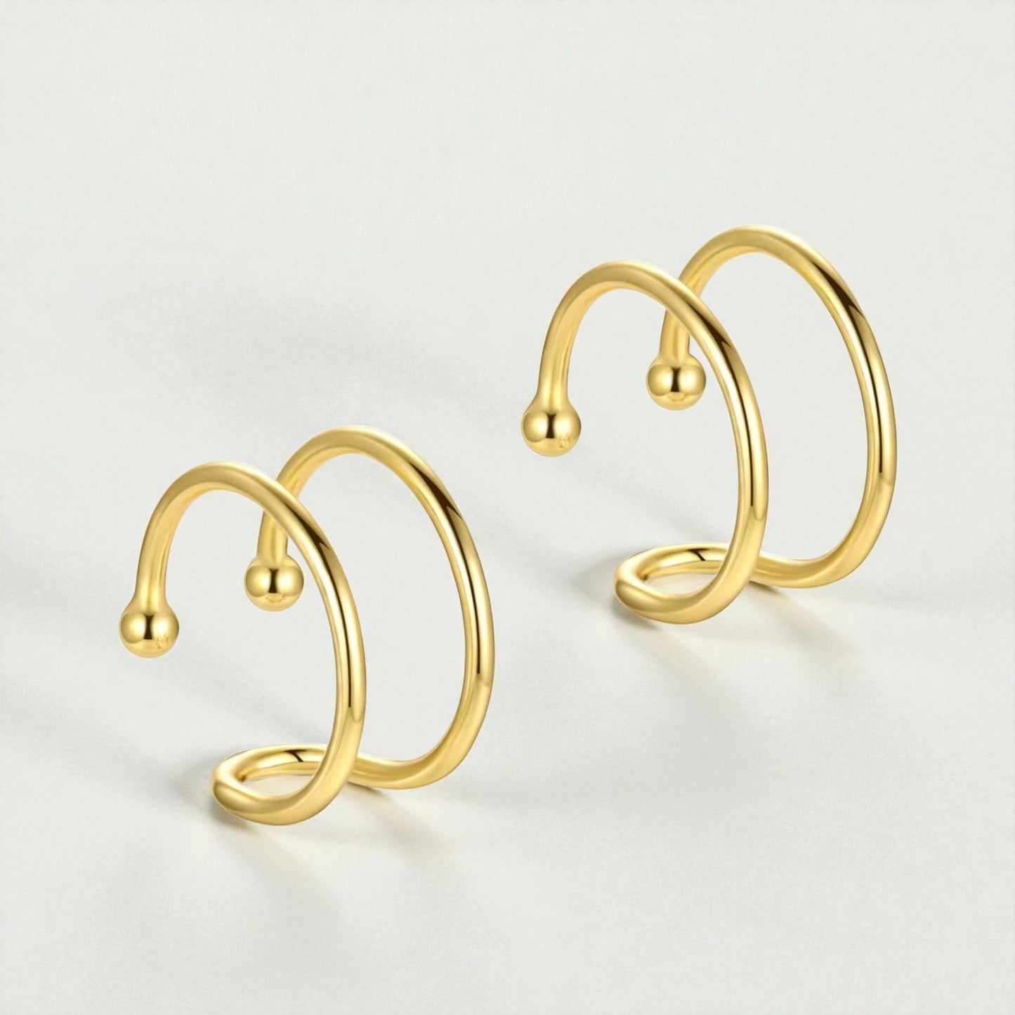 18K gold plated sterling silver double loop ear cuffs displayed on light background showing minimalist non-pierced hoop design for women