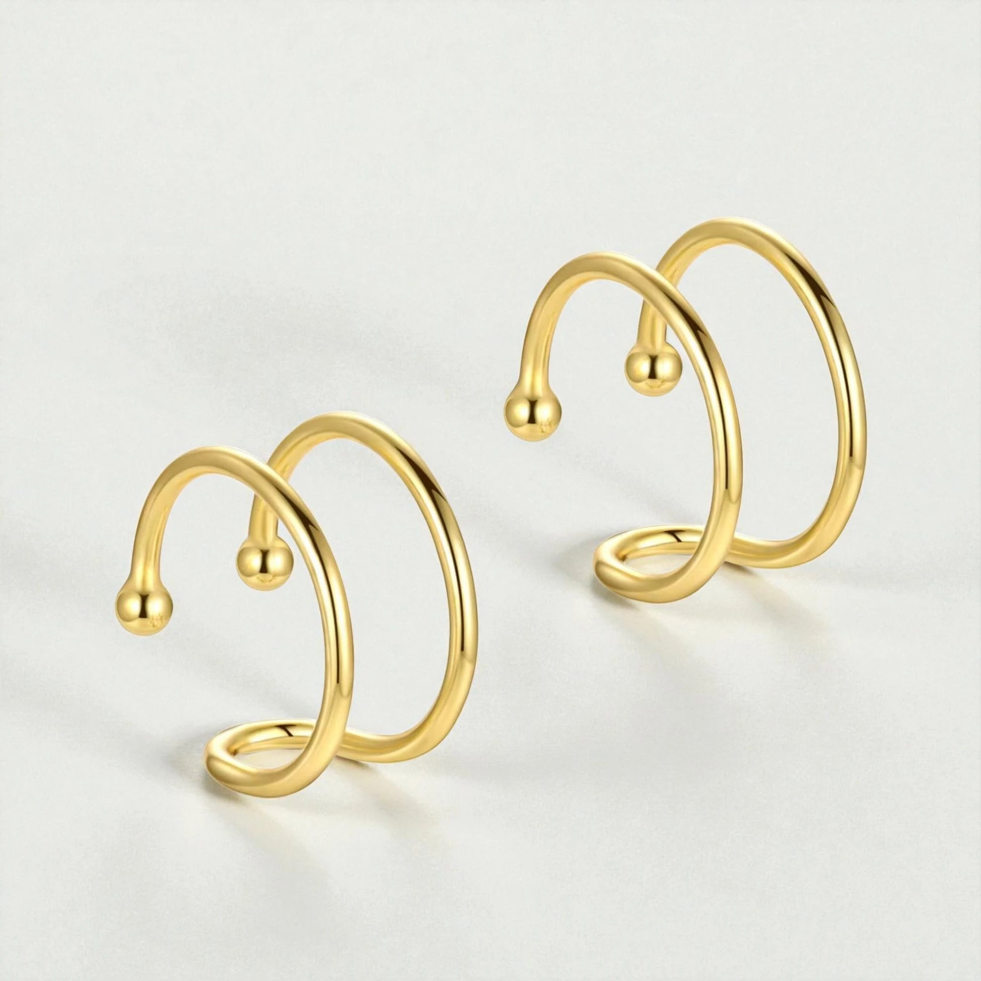 18K gold plated sterling silver double loop ear cuffs displayed on light background showing minimalist non-pierced hoop design for women