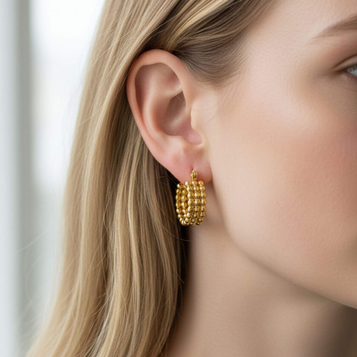 Close-up of 18K gold plated triple bead hoop earrings with layered bead detail