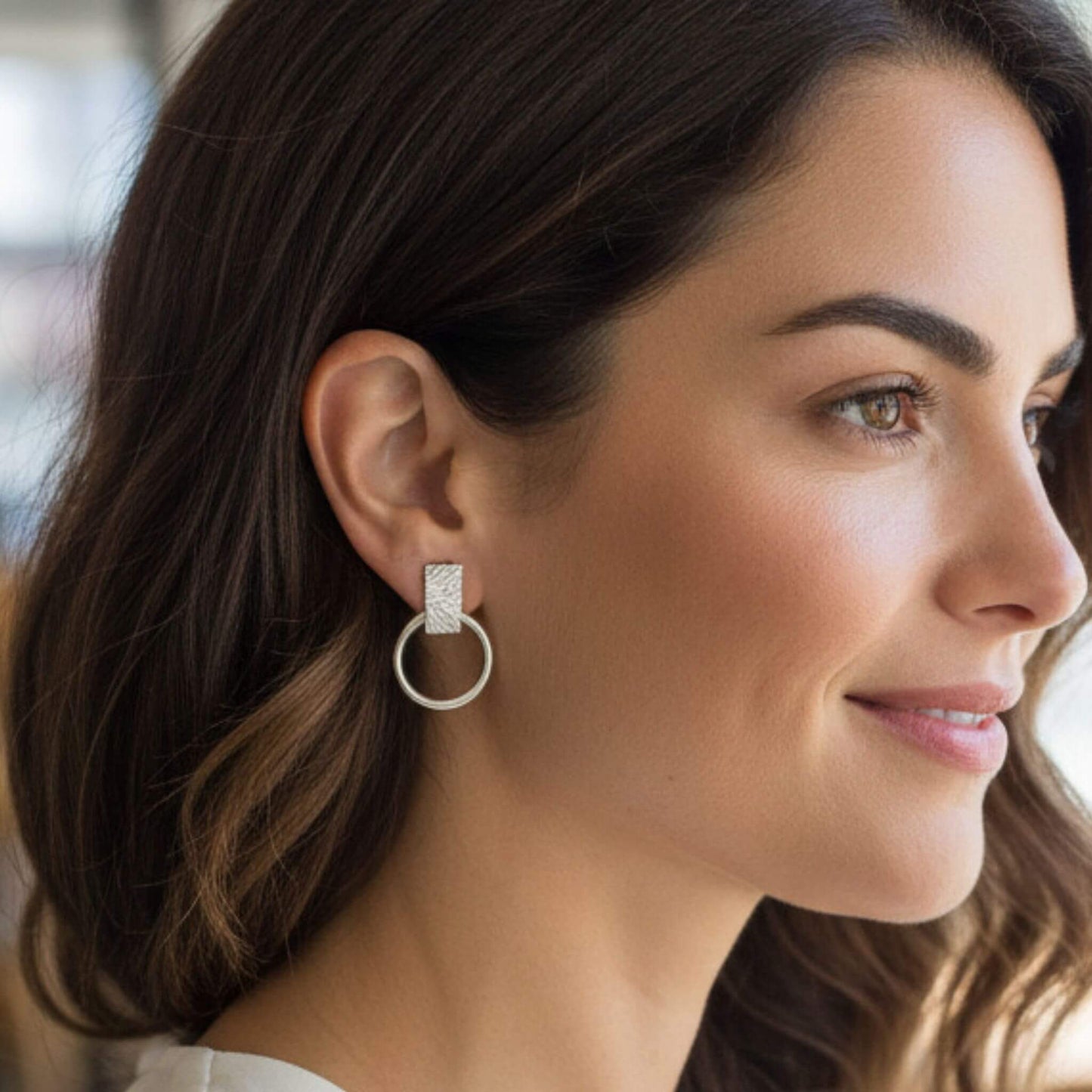 Close-up of 925 sterling silver bar and open circle drop stud earring on model's ear, showing textured bar detail