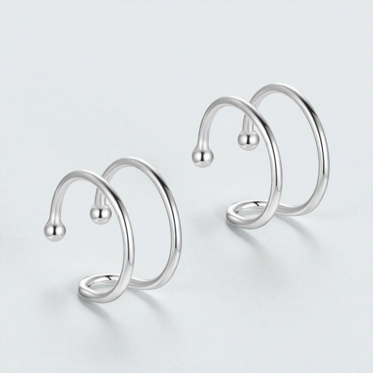 Pair of 925 sterling silver double loop ear cuffs displayed on light background showing minimalist non pierced hypoallergenic hoop design