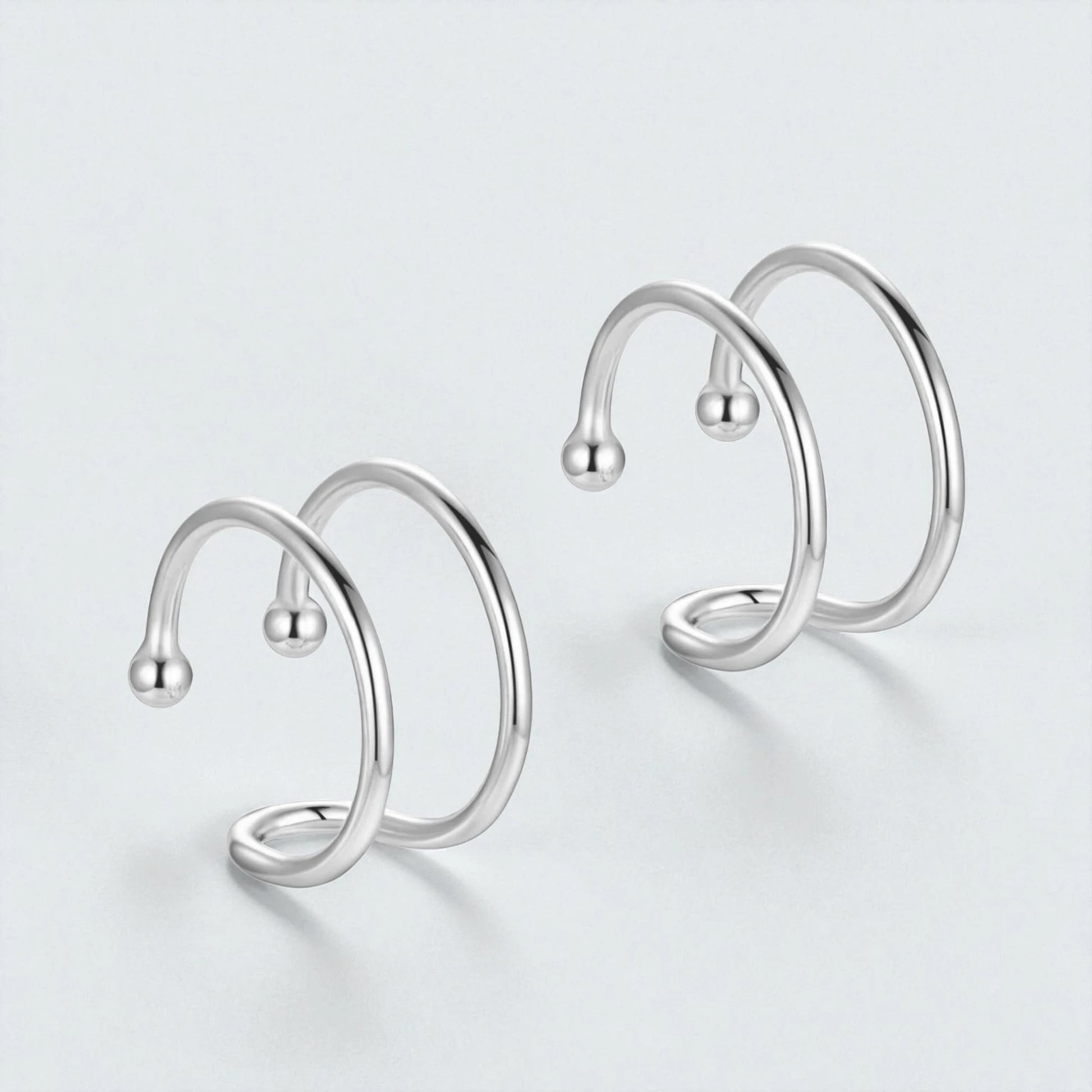 Pair of 925 sterling silver double loop ear cuffs displayed on light background showing minimalist non pierced hypoallergenic hoop design