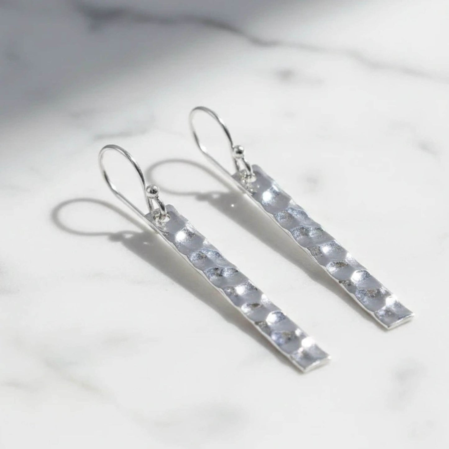 925 sterling silver hammered bar drop earrings on marble surface, showing hand-textured rectangle silver bars on French hook wire, pair