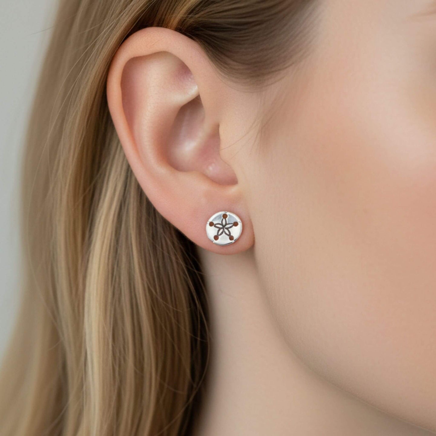 925 sterling silver sand dollar stud earrings close-up on ear, beach inspired silver jewelry