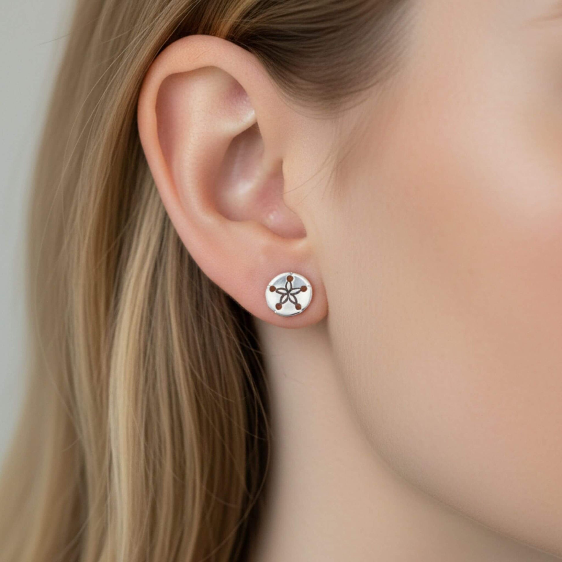 925 sterling silver sand dollar stud earrings close-up on ear, beach inspired silver jewelry