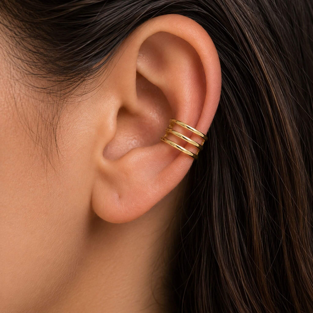 Close-up of a model wearing an 18K gold plated sterling silver gold ear cuff with a comfortable non-piercing cartilage fit.