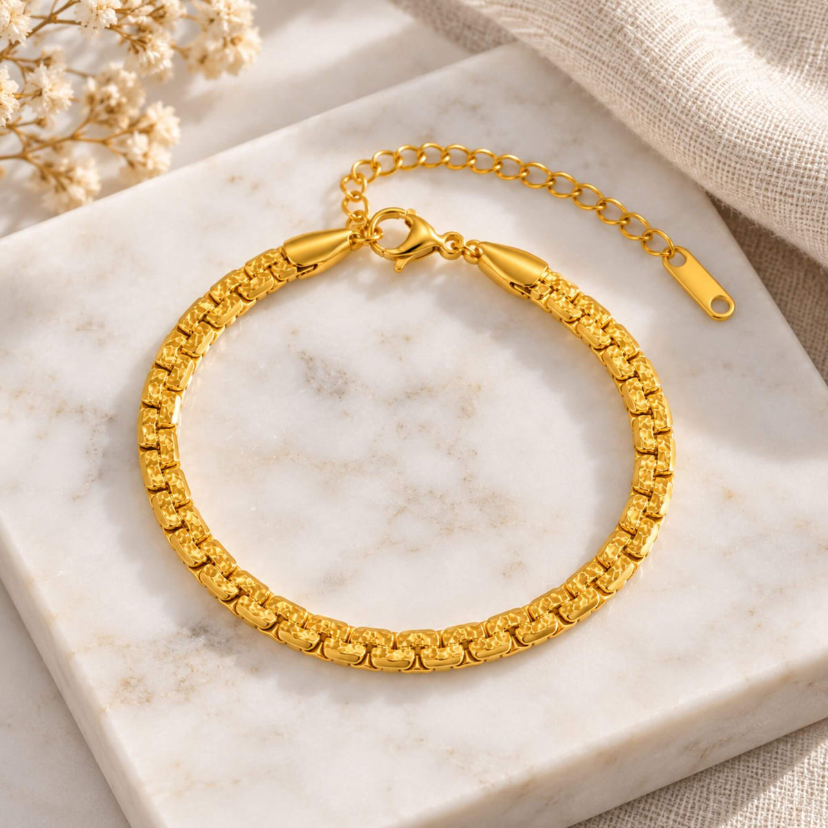 18K gold plated stainless steel link bracelet with lobster clasp and extender displayed on marble