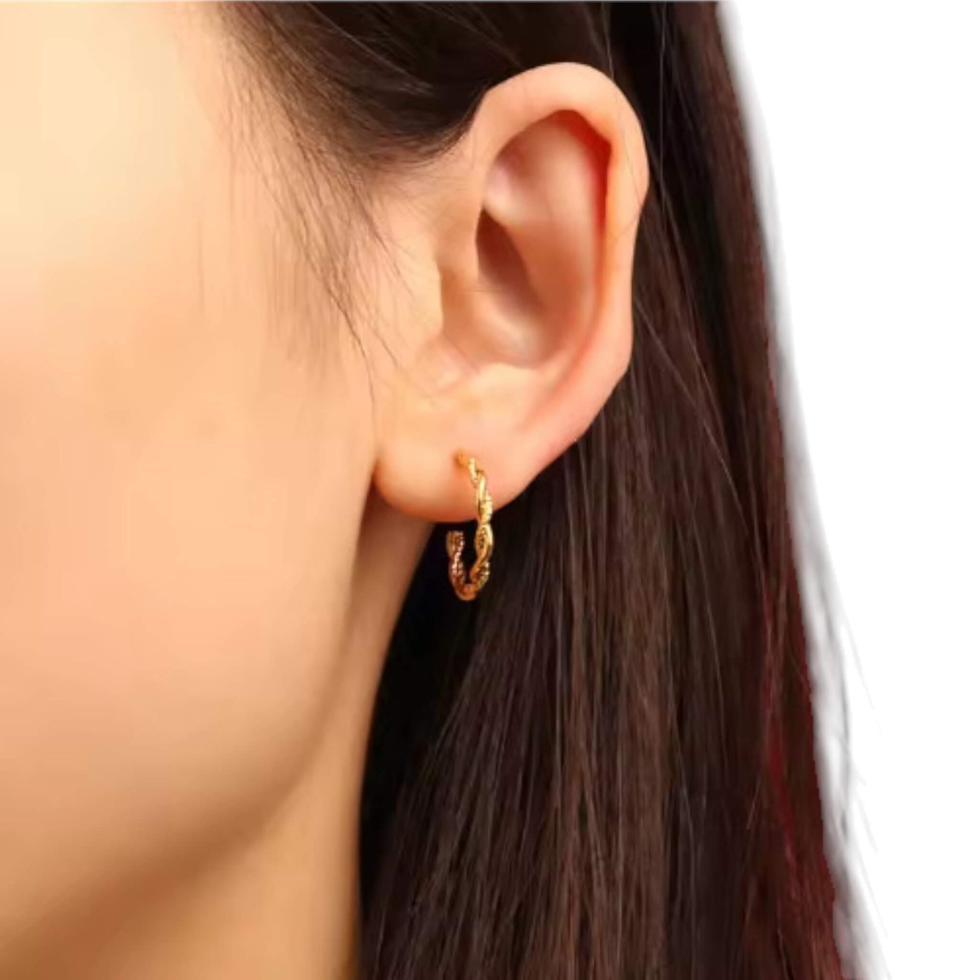 Small gold rope twist hoop earrings worn on ear