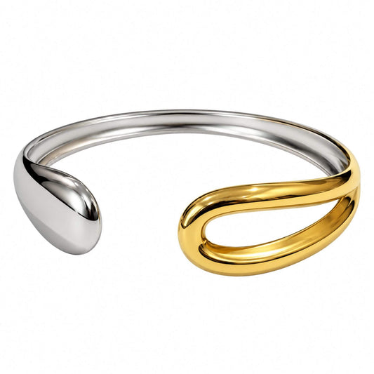 Sculptural gold and silver cuff bracelet with an elongated gold loop and rounded silver-tone end on a white background.