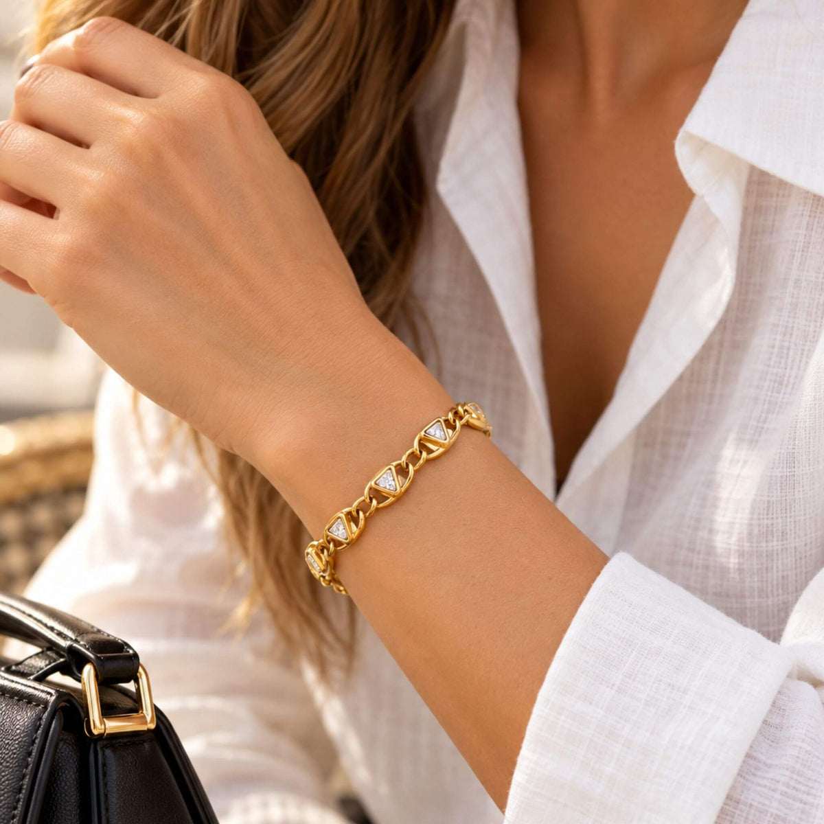 Woman wearing an 18K PVD gold plated tennis bracelet with triangular white zircon stones