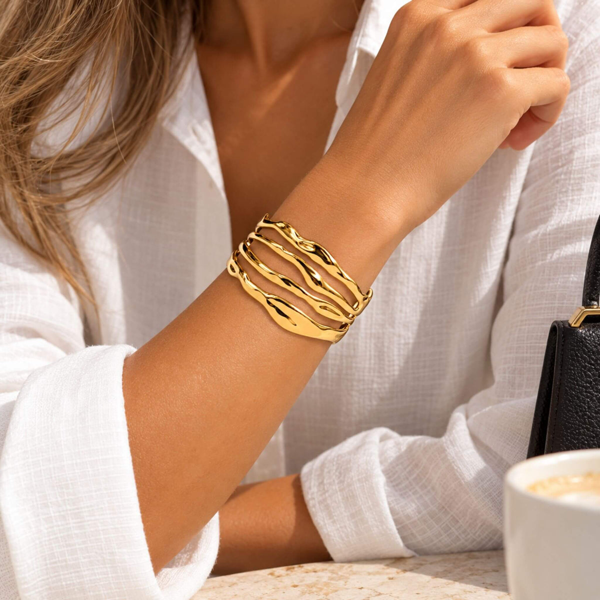 Gold wave cuff bracelet for women styled with a white blouse for an everyday statement jewelry look