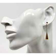 Long gold plated teardrop earrings with a shimmering finish
