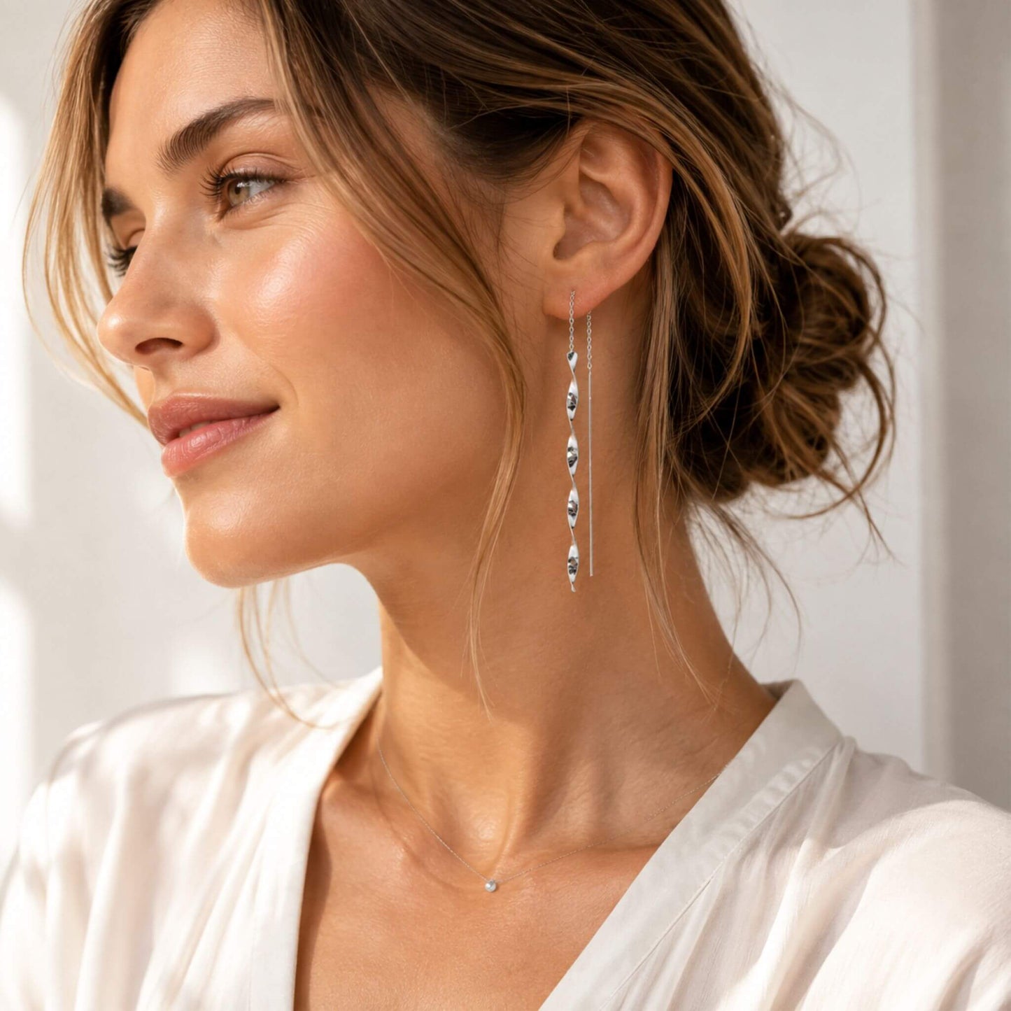 Woman wearing minimalist sterling silver threader earrings with spiral twist