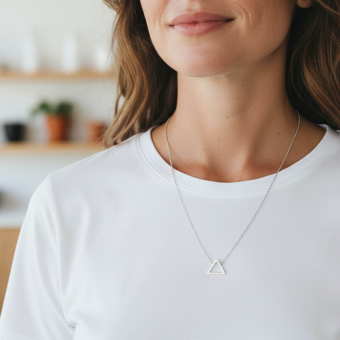 Minimalist sterling silver triangle pendant necklace worn for everyday style