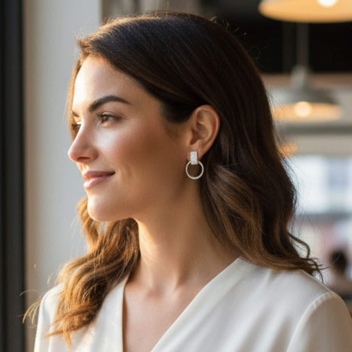 Modern sterling silver circle drop stud earrings on model, side profile in natural light, everyday wear jewelry