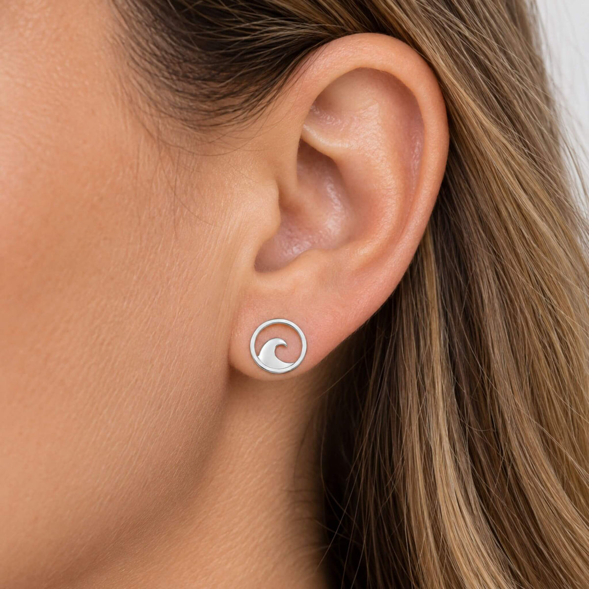 Ocean wave stud earrings in sterling silver worn on ear