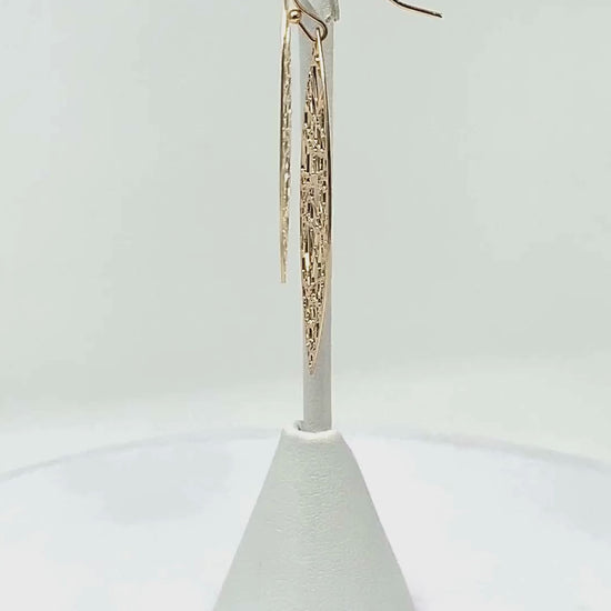 Close-up view of gold teardrop earrings, showcasing the intricate random line detail.