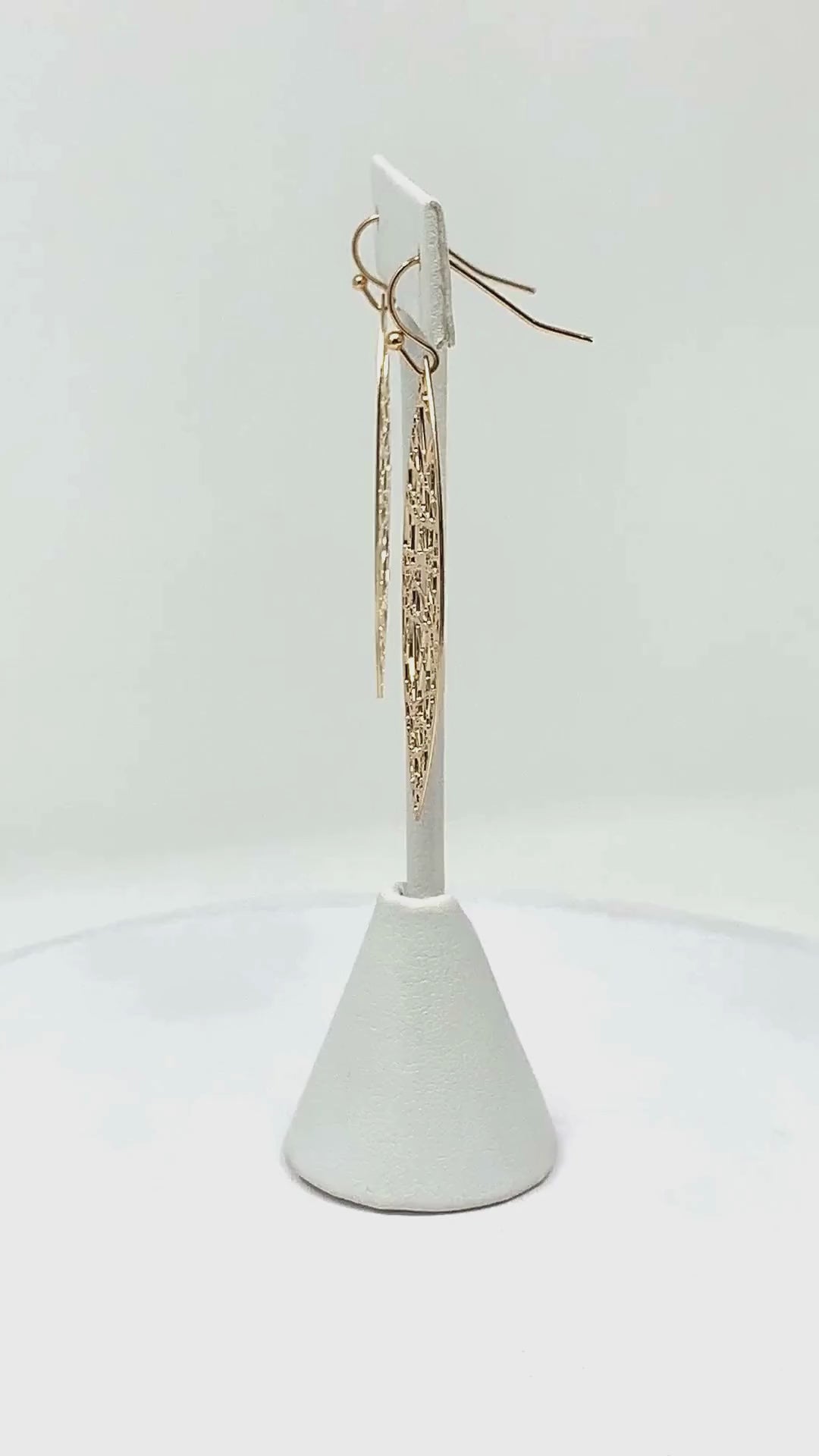 Close-up view of gold teardrop earrings, showcasing the intricate random line detail.
