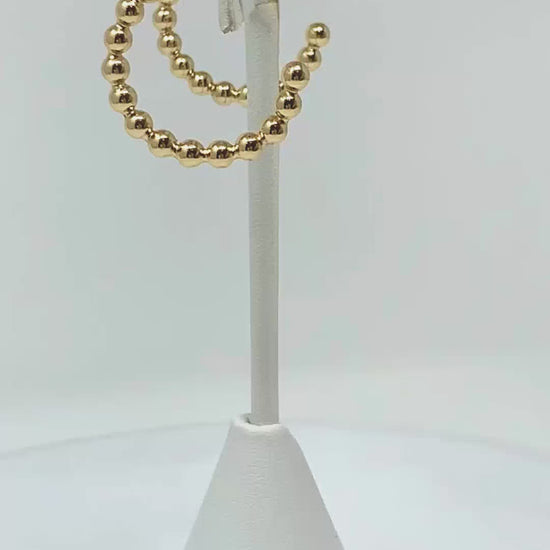 Ball beaded hoop earrings add a touch of sophistication to any occasion.