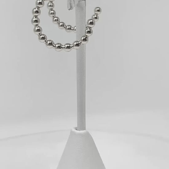 Ball beaded hoop earrings add a touch of sophistication to any occasion.