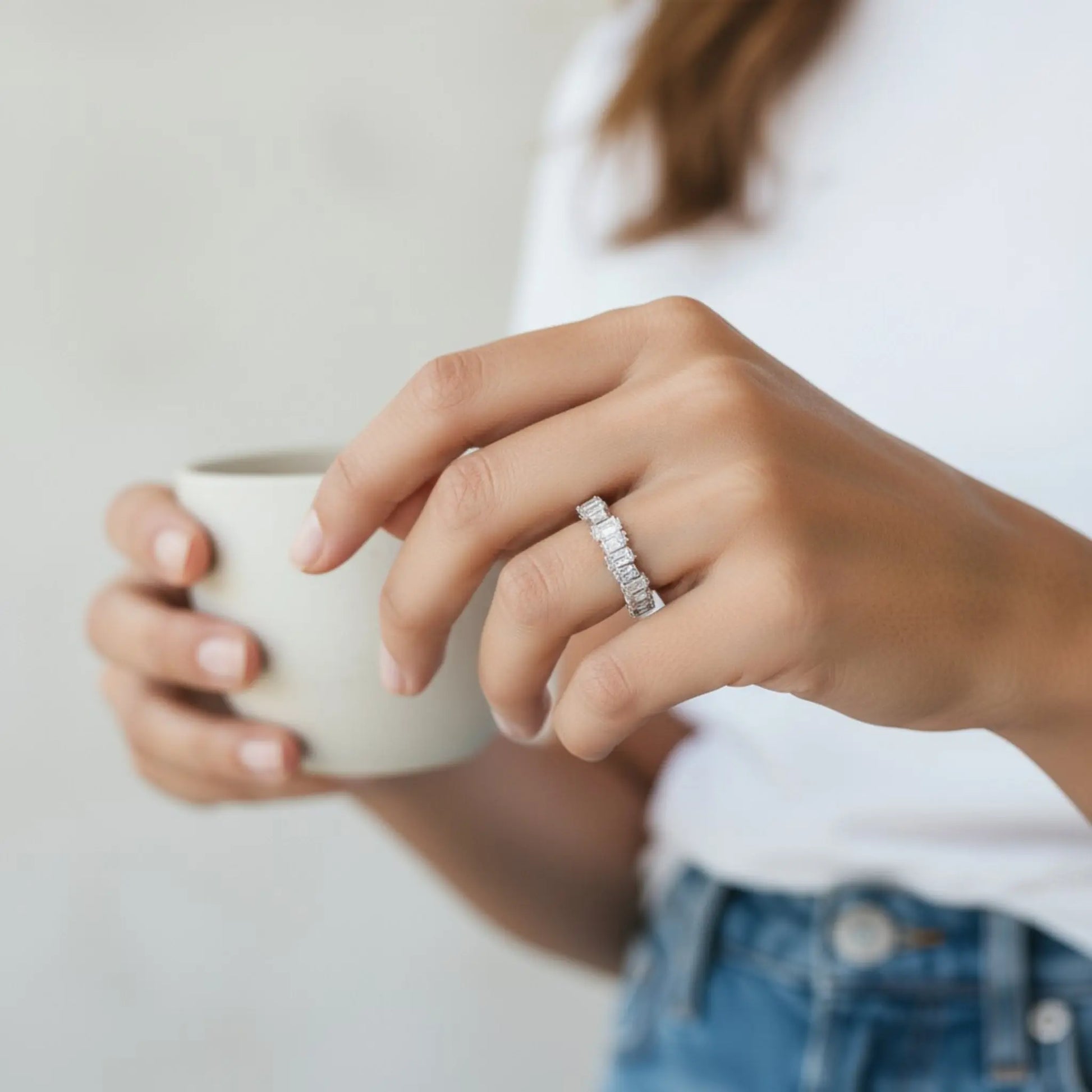 Model wearing silver 5A cubic zirconia open ring while holding a cup in casual lifestyle setting showing sparkle and comfort fit