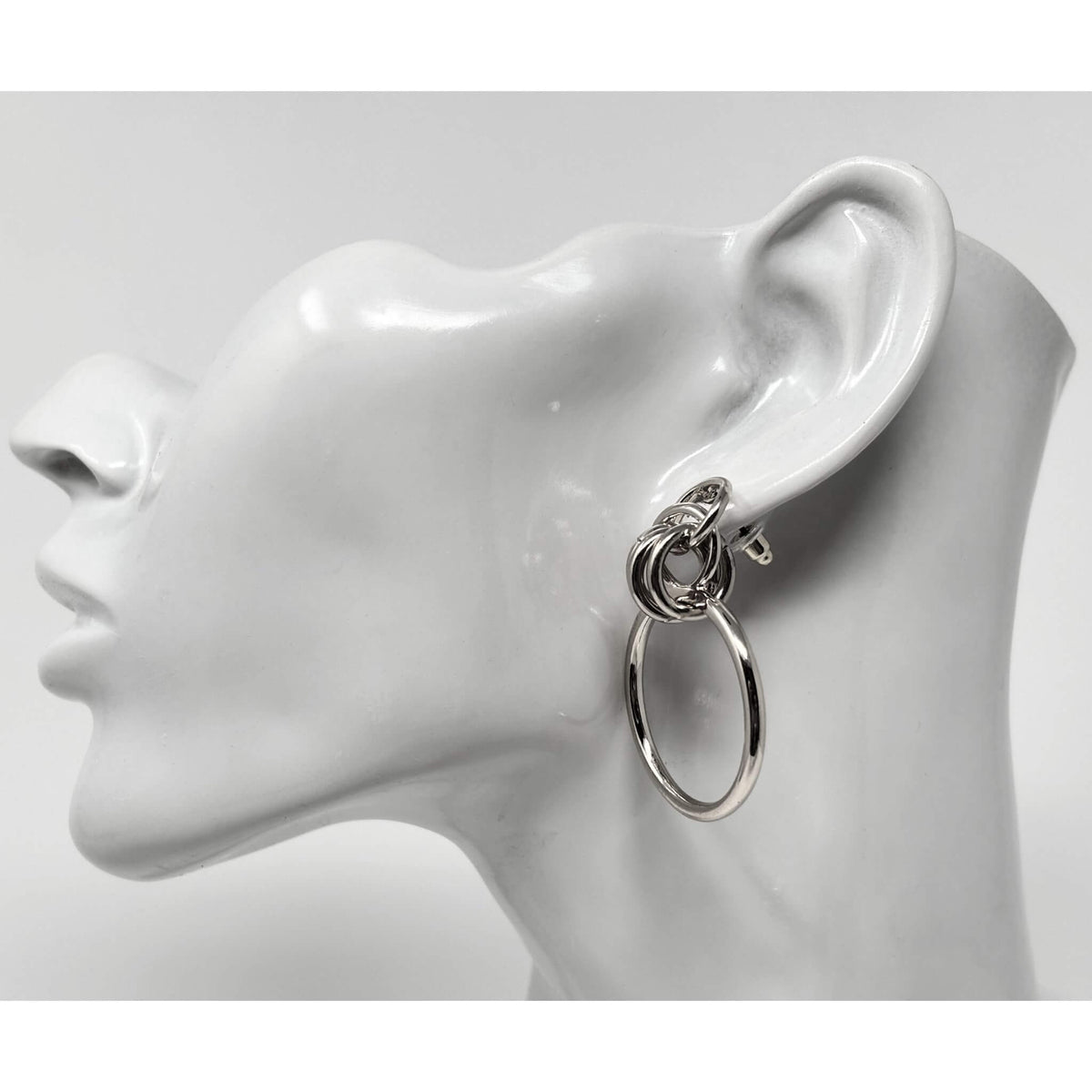 Side view of silver door knocker hoop stud earrings, featuring minimalist layered hoops for a sleek look.