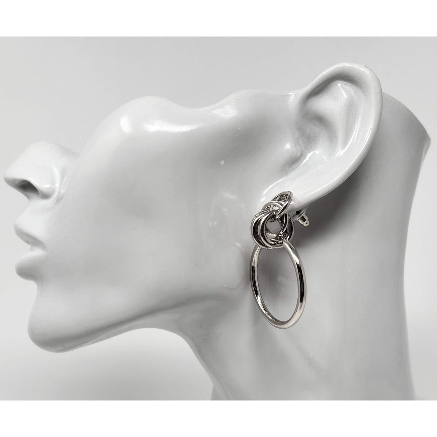 Side view of silver door knocker hoop stud earrings, featuring minimalist layered hoops for a sleek look.