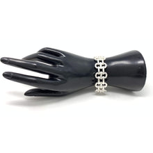 Silver link cuff stretch bracelet that can be stacked with other bracelets.
