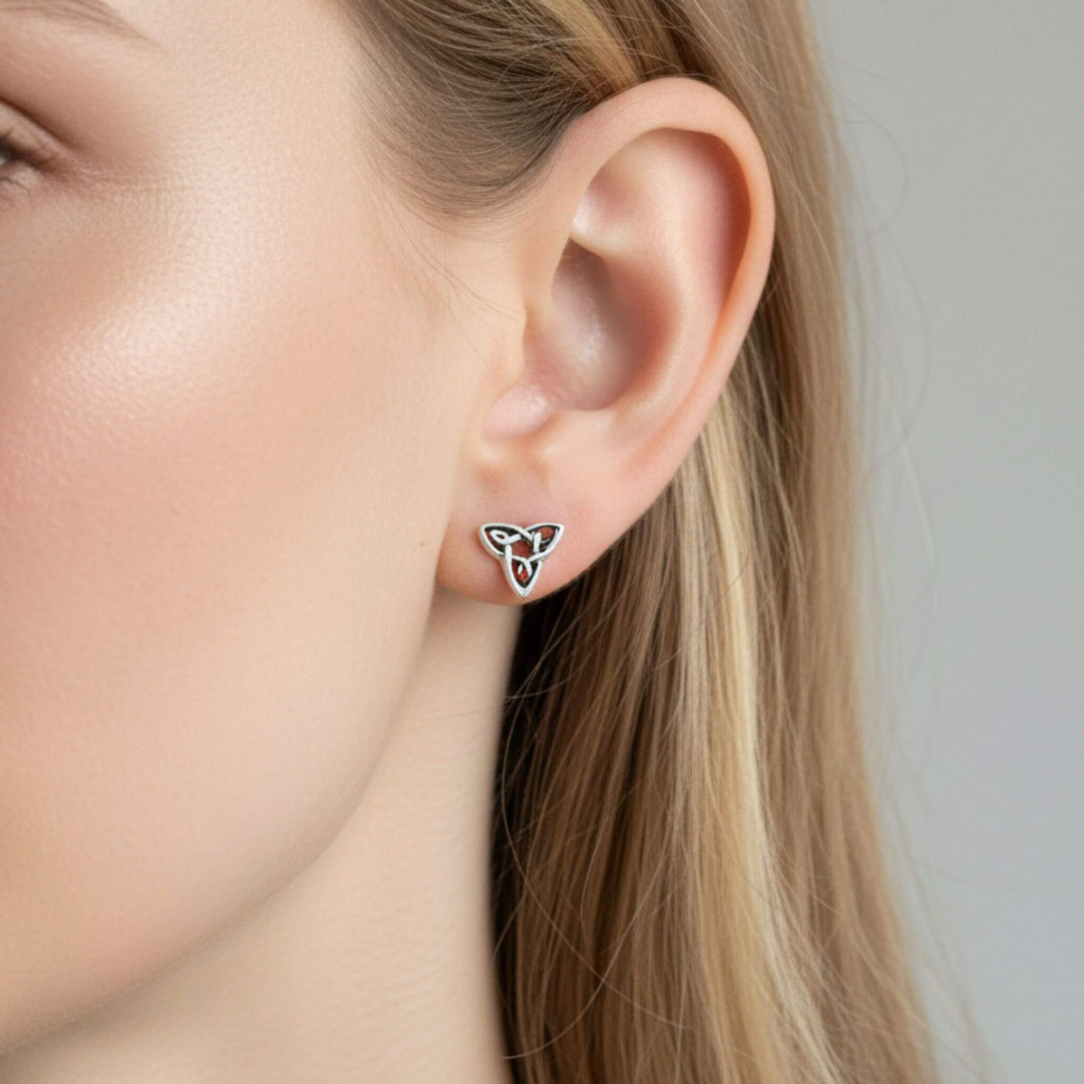 Sterling silver Celtic trinity knot stud earrings close-up on ear, Irish knot jewelry