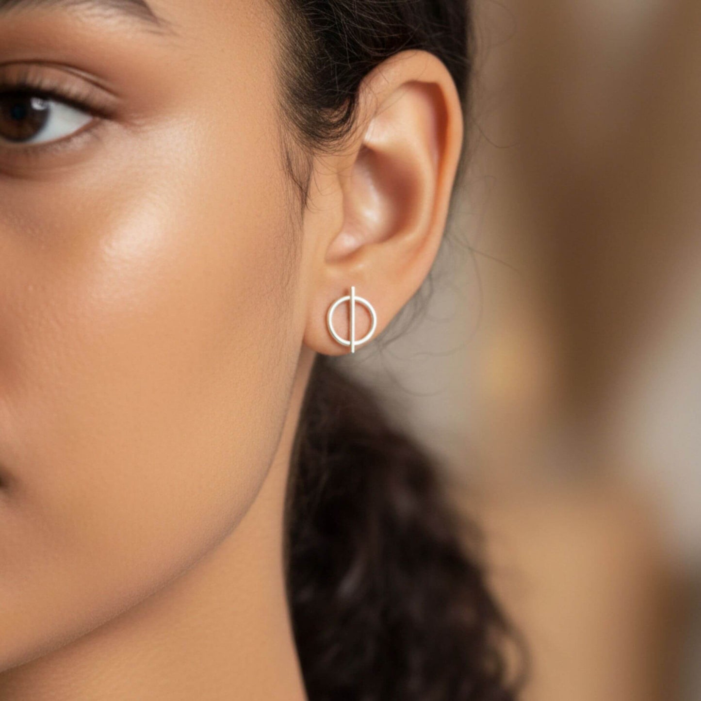 Sterling silver circle and bar stud earrings worn on ear
