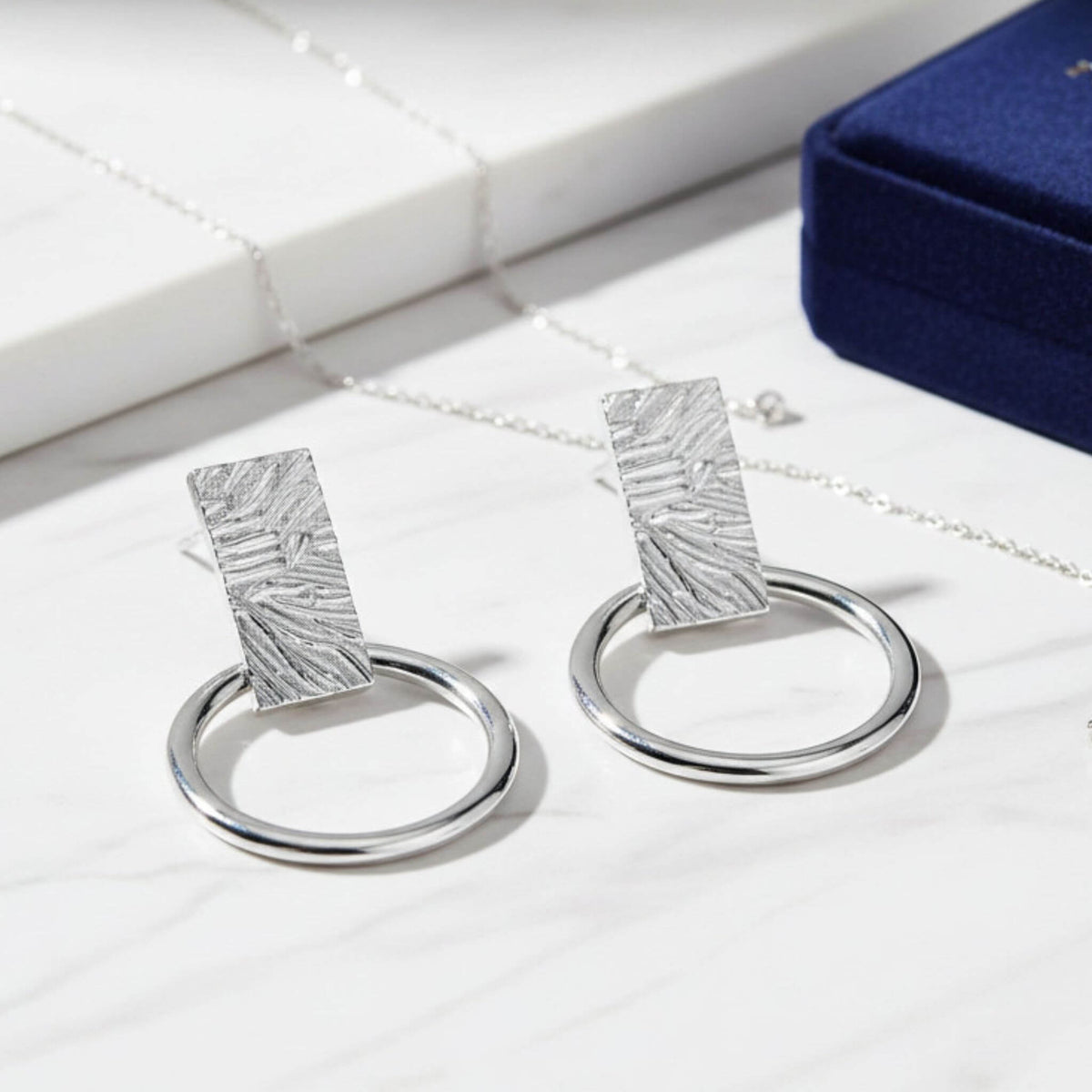 925 sterling silver open circle and bar stud earrings on marble surface with matching necklace
