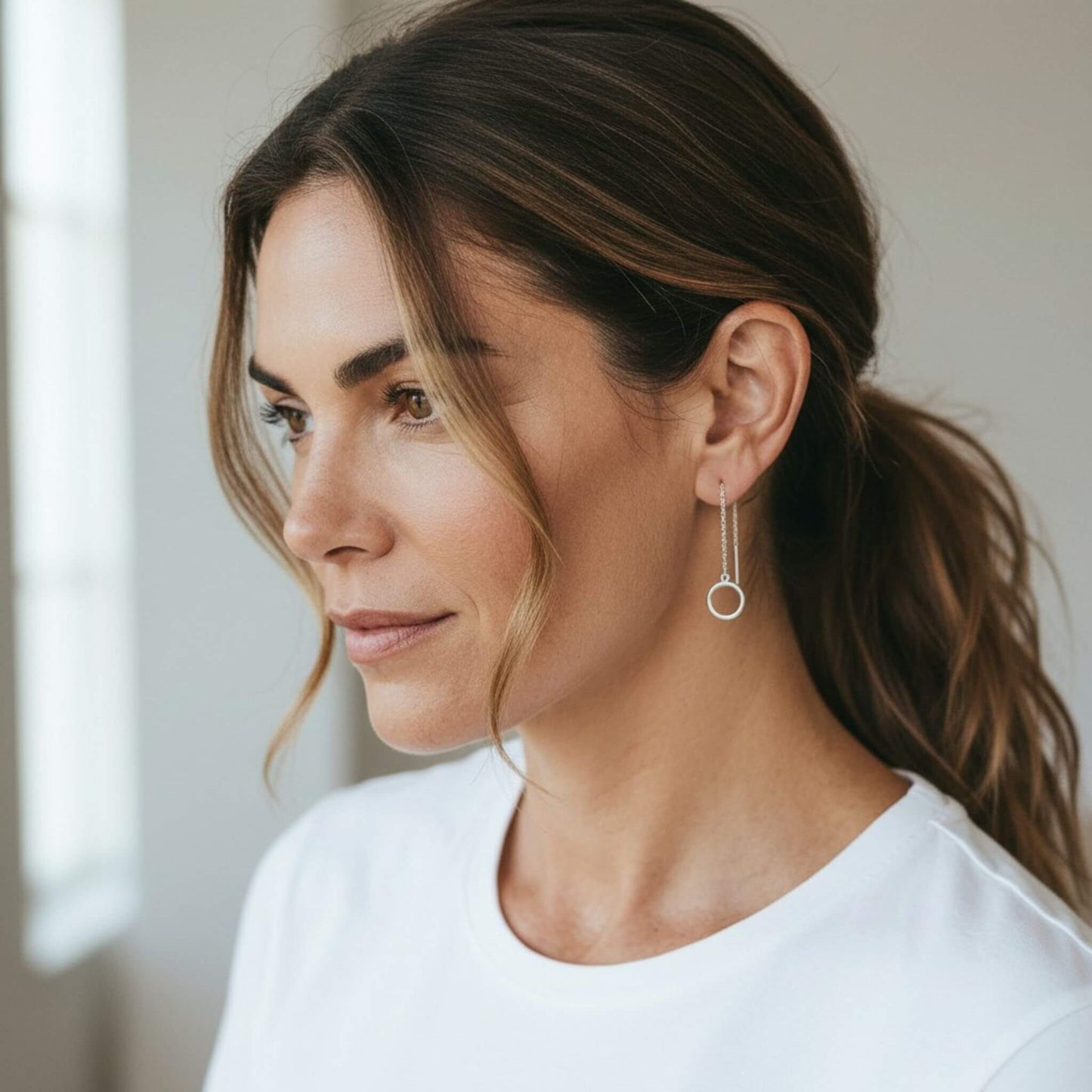 Sterling silver circle threader earrings on model with loose hair — hypoallergenic earrings for sensitive ears