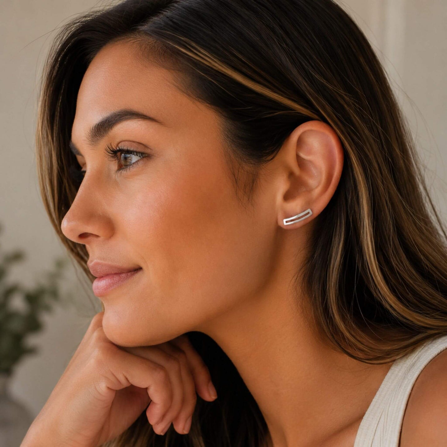 Woman wearing minimalist sterling silver rectangle ear climber earrings.