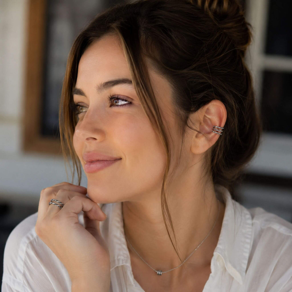 Woman wearing a sterling silver ear cuff no piercing with a minimalist twisted cartilage ear cuff design.