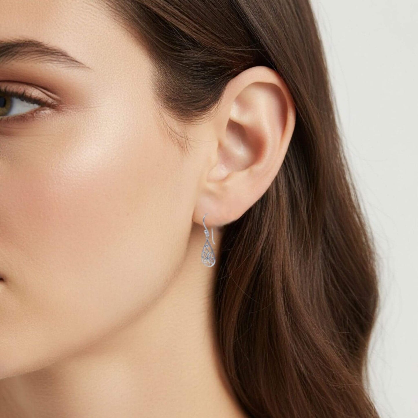 Sterling silver floral drop earrings worn on model close up