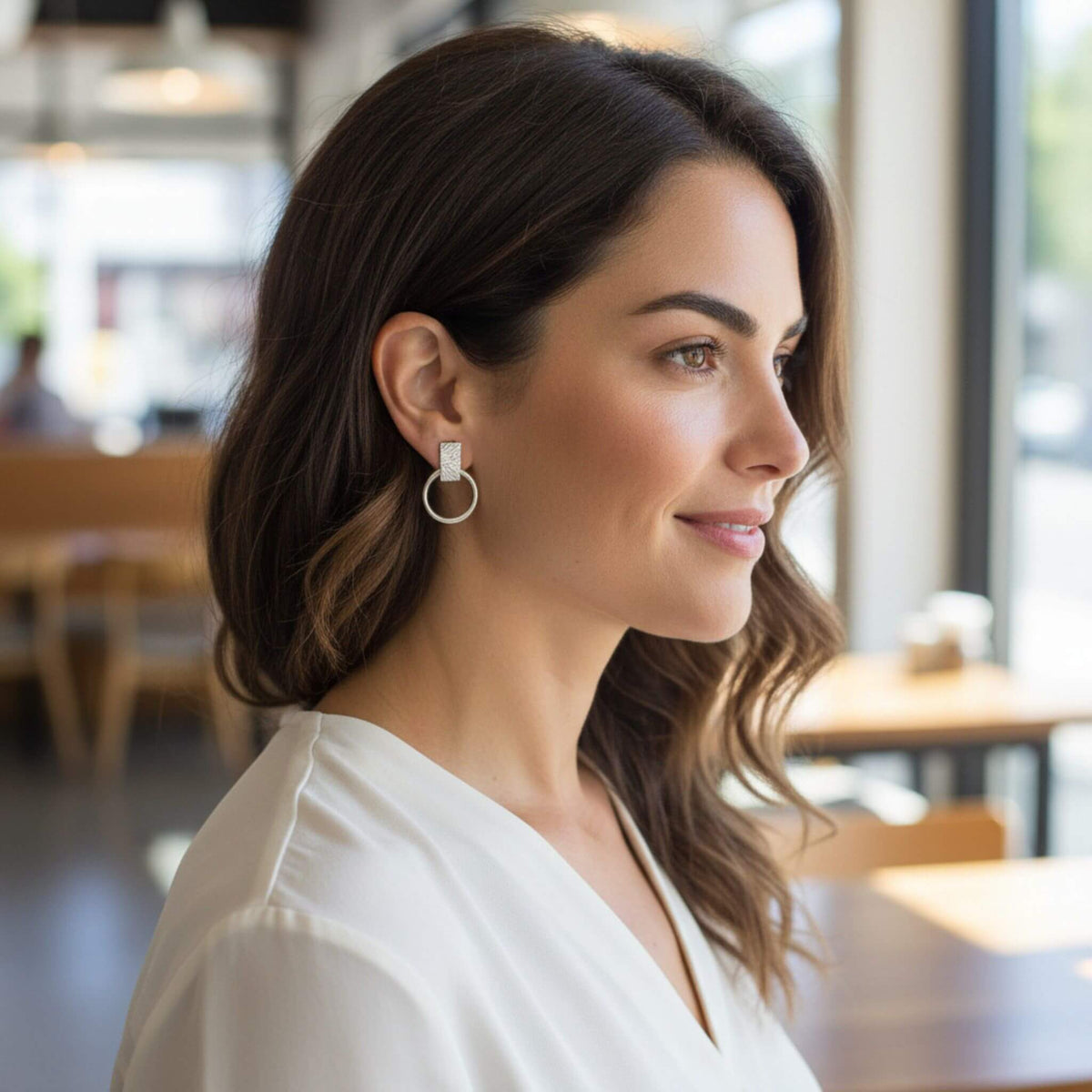 Sterling silver geometric circle bar stud earrings worn by model in profile, modern everyday jewelry style