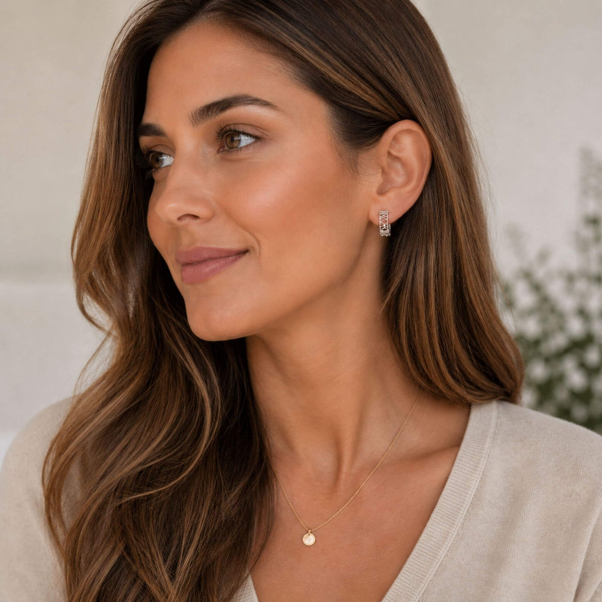 Woman wearing small sterling silver hoop earrings with modern wire wrapped design