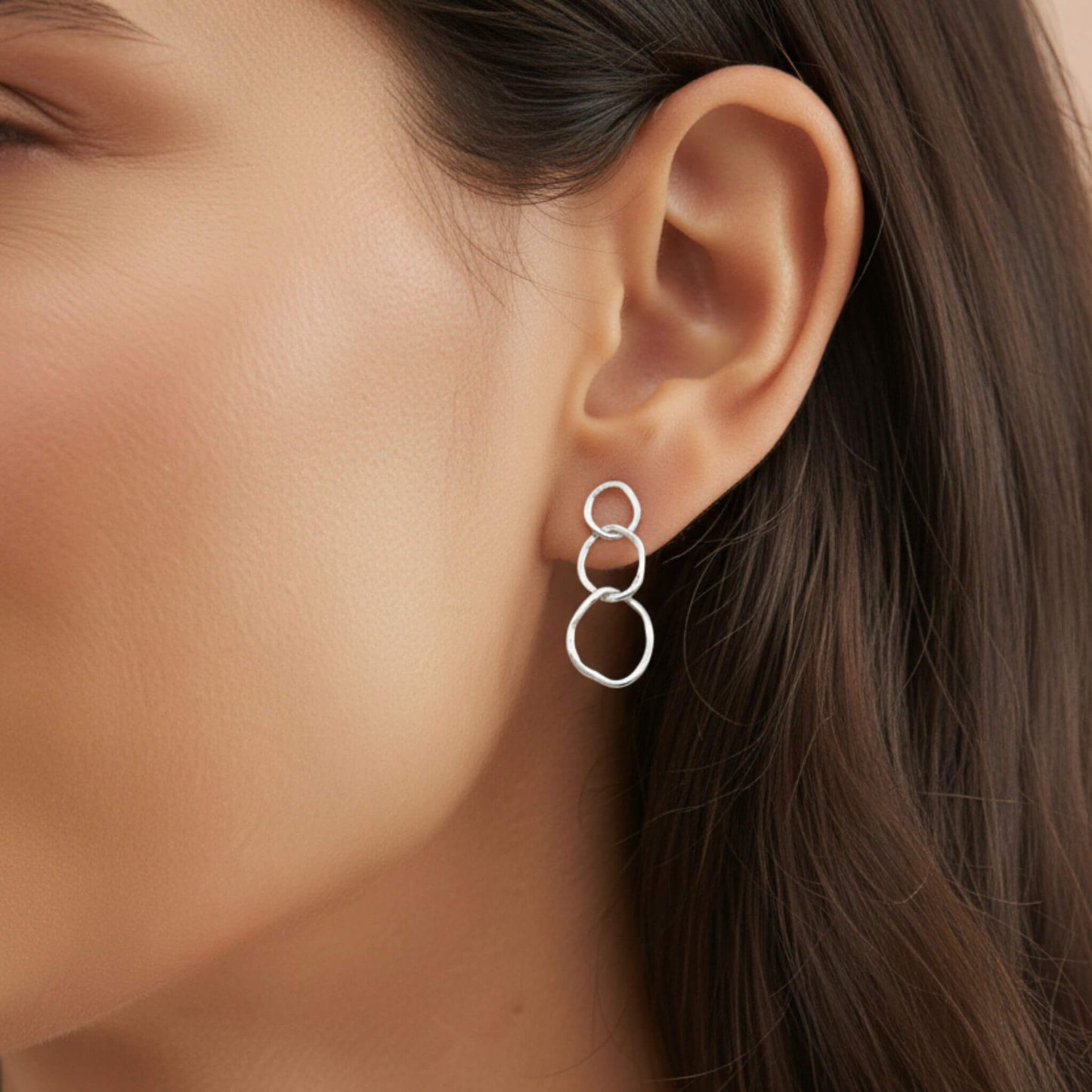 Sterling silver interlocking circle dangle earrings worn on ear