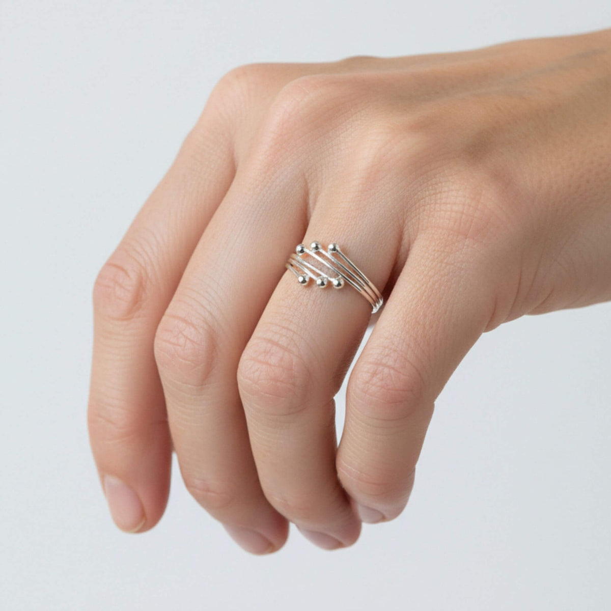 Sterling silver stackable ball ring shown on hand from alternate angle