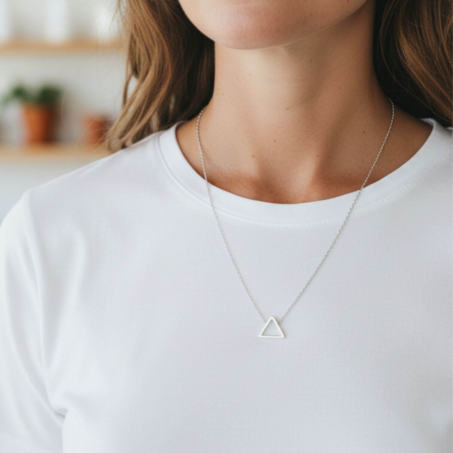 Minimalist sterling silver triangle necklace worn on model showing pendant size and fit