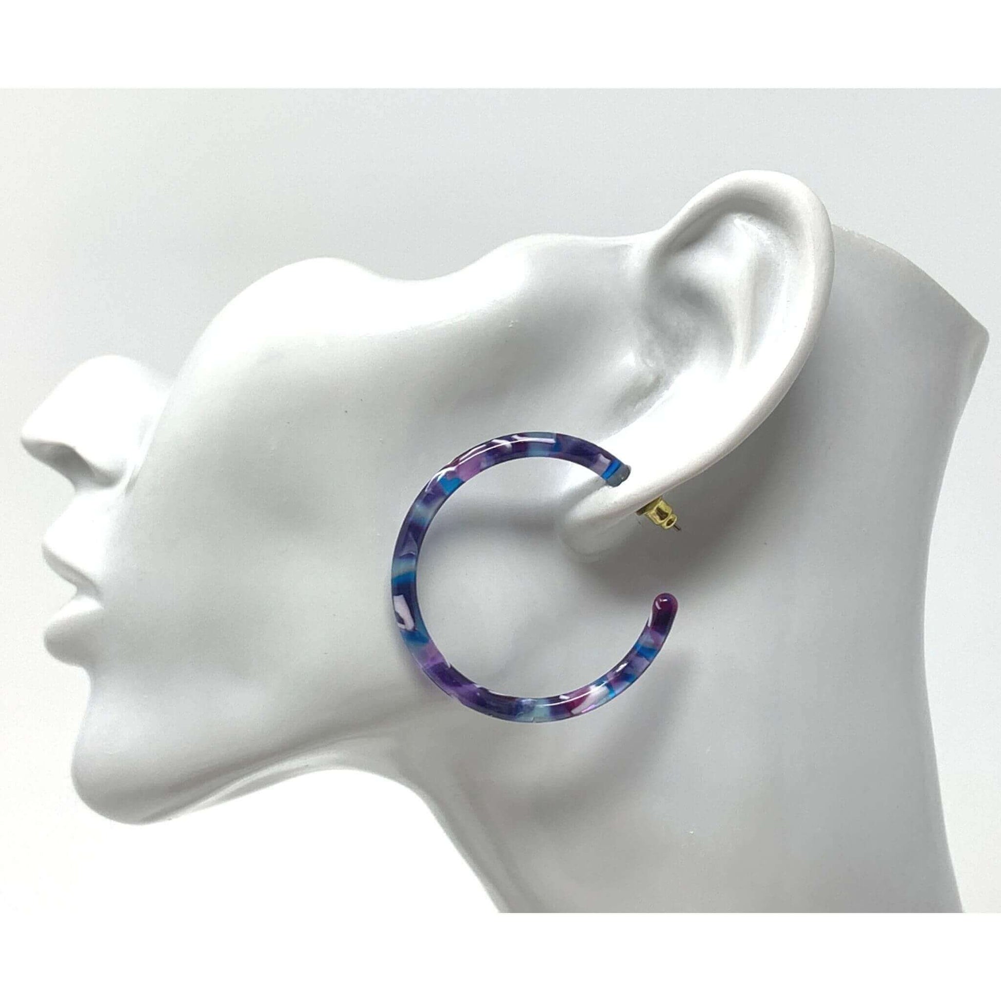 A pair of statement resin hoop earrings with a bold and eye-catching design